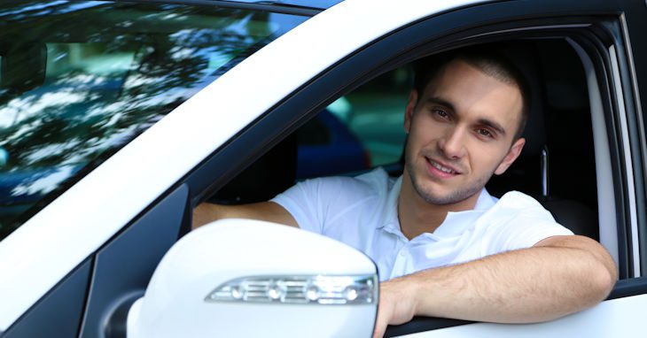 Young man behind the wheel of his car