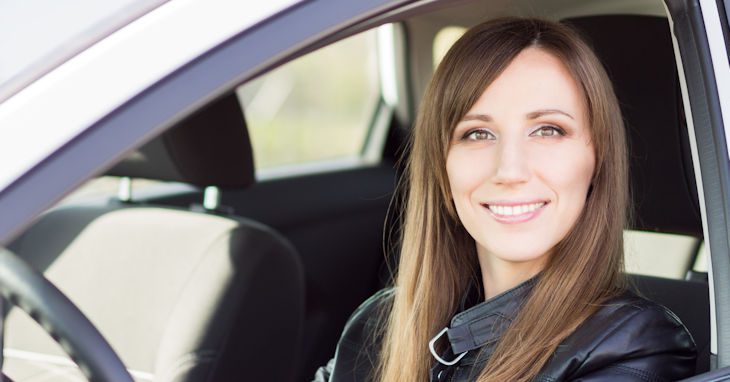 Young woman behind the wheel of her car